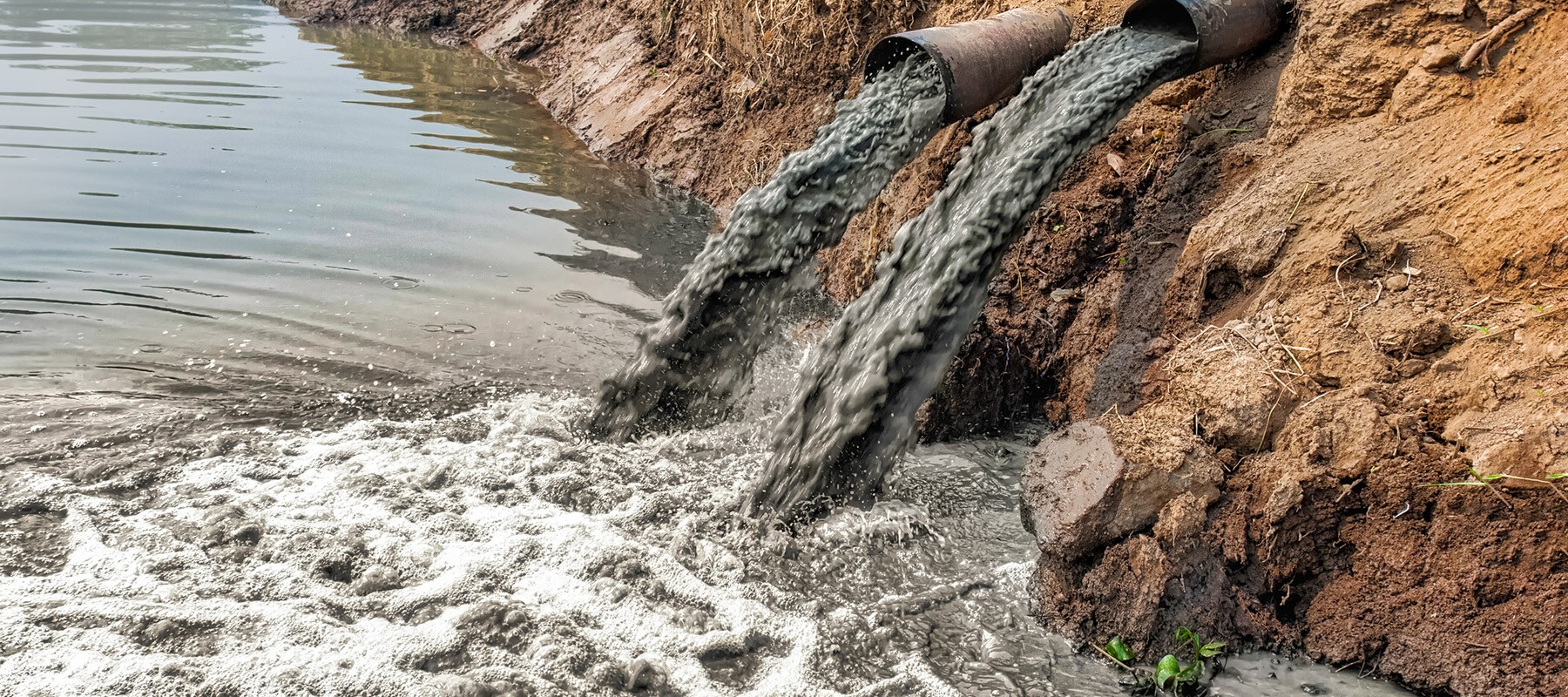 Pipes pumping polluted water into a river
