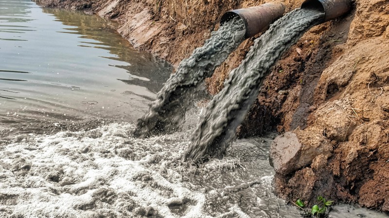 Pipes pumping polluted water into a river